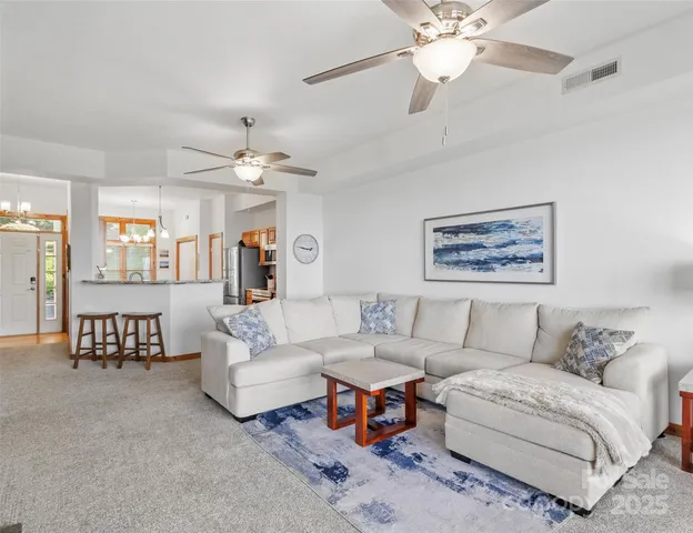 a living room with furniture a bed and a chandelier