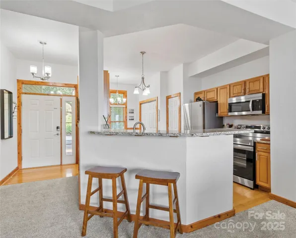 a kitchen with stainless steel appliances kitchen island granite countertop a refrigerator and microwave