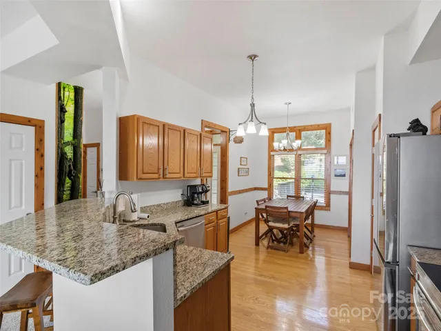 a kitchen with granite countertop a sink a counter top space and stainless steel appliances