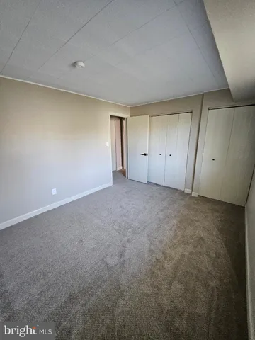 a bathroom with a granite countertop toilet sink and mirror