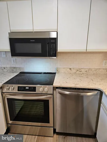 a stove top oven sitting inside of a kitchen