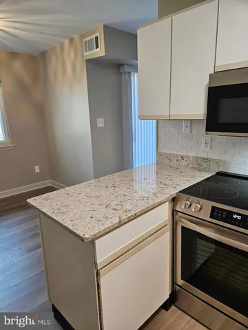 a kitchen with stainless steel appliances granite countertop a sink stove and microwave