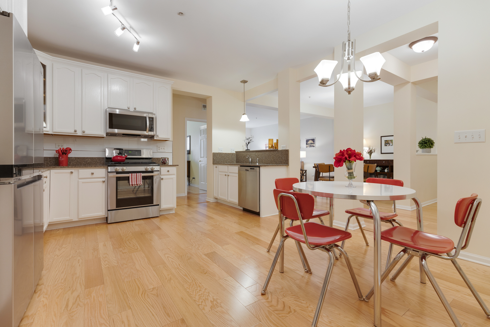 1386 Scarboro Road, Unit 1102 Schaumburg, IL 60193 - Photo 5 of 26 a kitchen with stainless steel appliances kitchen island granite countertop a table chairs and a refrigerator