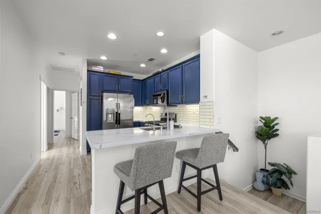 a kitchen with granite countertop wooden cabinets stainless steel appliances and a sink