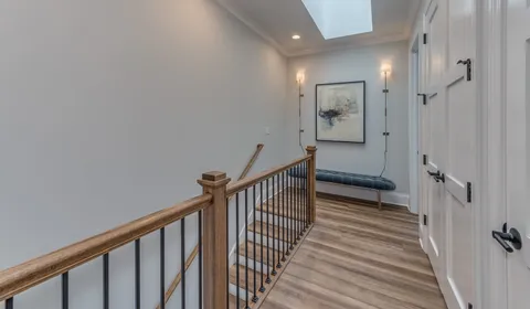 a view of a hallway with wooden floor and staircase