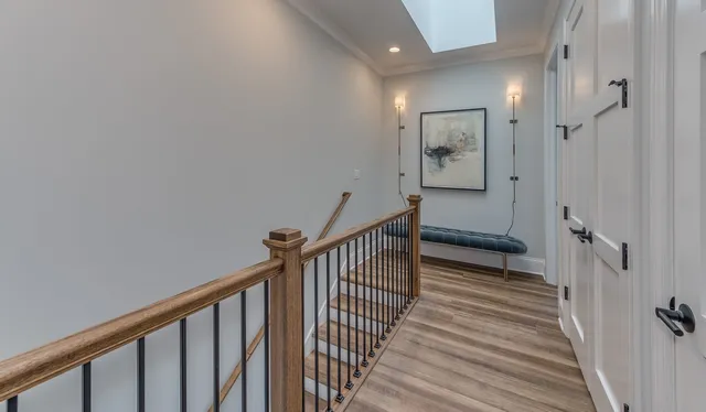 a view of a hallway with wooden floor and staircase