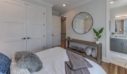 a bedroom with a bed a mirror and a table