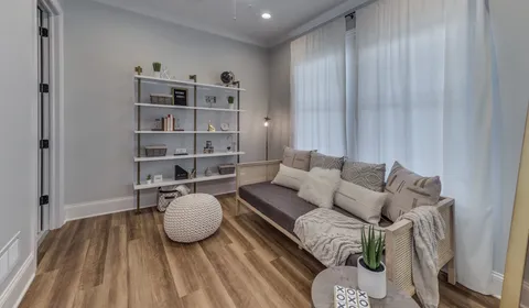 a living room with furniture and a book shelf