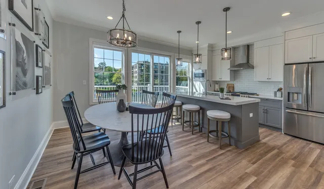 a view of a dining room with furniture large window a chandelier and wooden floor