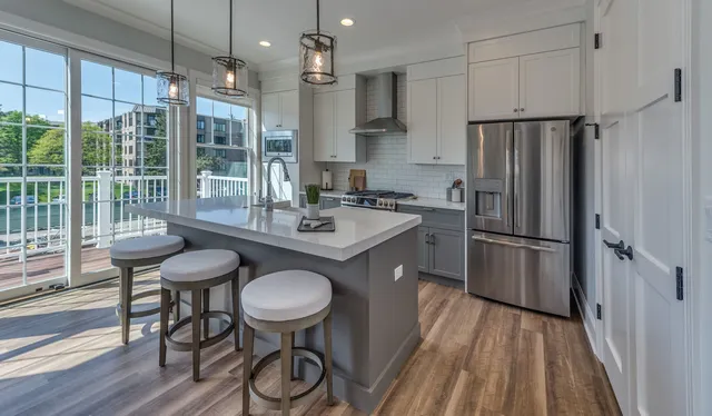 a kitchen with refrigerator a sink and chairs