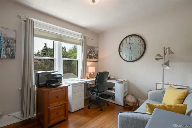a view of a workspace with furniture and a window
