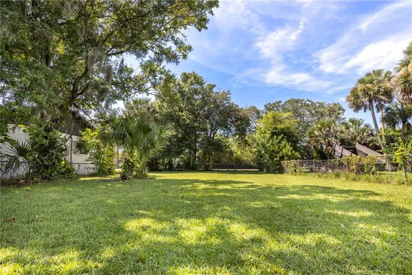 a view of a grassy field with trees