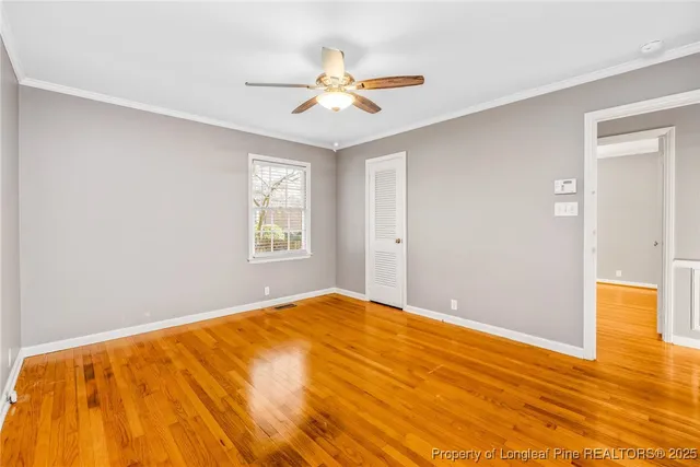 a view of a big room with wooden floor and a ceiling fan