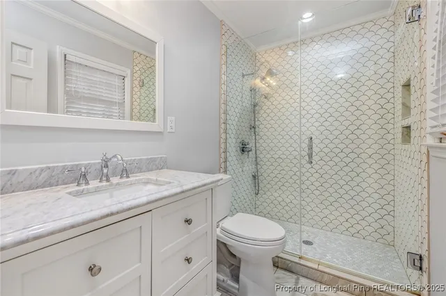 a bathroom with a granite countertop sink a toilet and shower