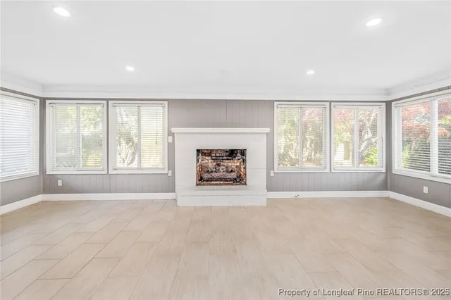 a view of an empty room with a window and a fireplace