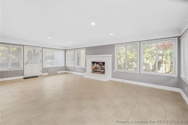 an empty room with fireplace and windows
