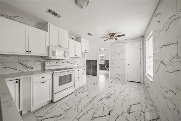 a kitchen with white cabinets and white appliances