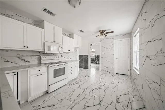 a kitchen with white cabinets and white appliances