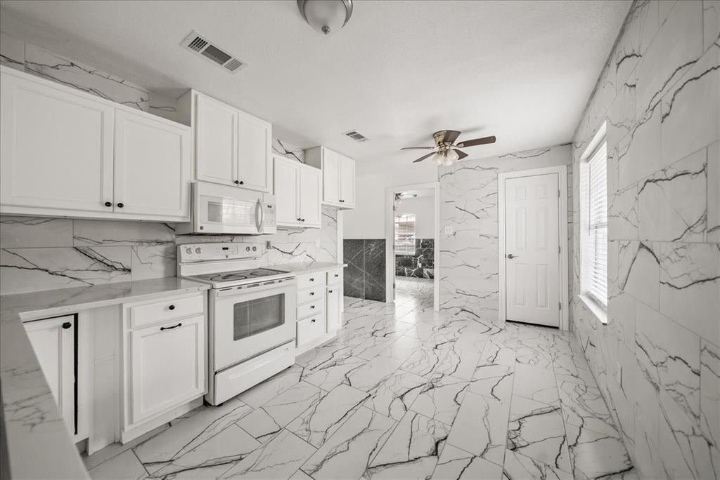 5507 Alexander Street Sachse, TX 75048 - Photo 11 of 18 a kitchen with white cabinets and white appliances