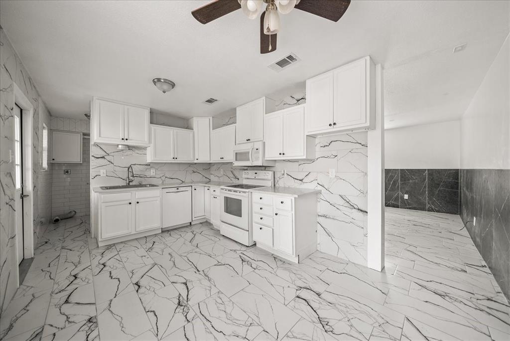 5507 Alexander Street Sachse, TX 75048 - Photo 7 of 18 a kitchen with white cabinets and white appliances
