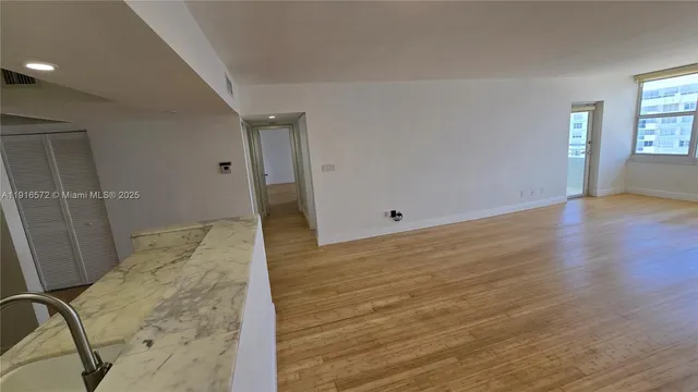 a view of empty room with wooden floor and window