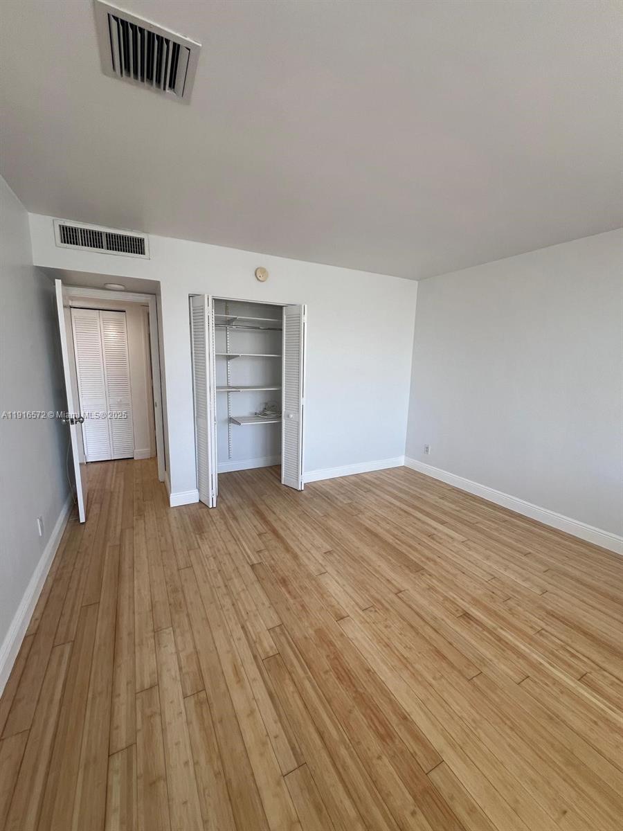 5600 Collins Avenue, Unit 17T Miami Beach, FL 33140 - Photo 19 of 52 a view of empty room with wooden floor and window