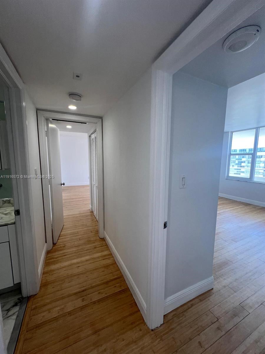 5600 Collins Avenue, Unit 17T Miami Beach, FL 33140 - Photo 26 of 52 a view of a hallway with wooden floor and staircase