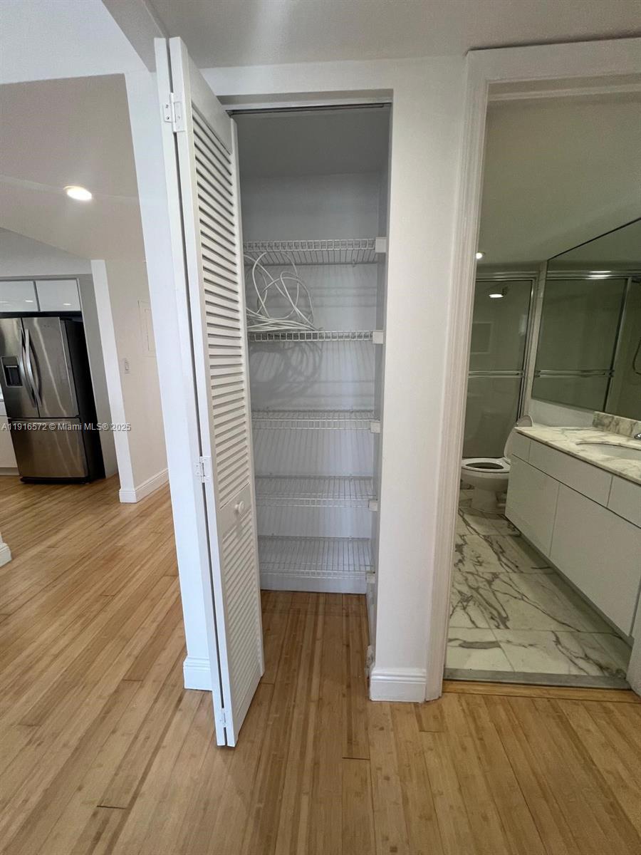 5600 Collins Avenue, Unit 17T Miami Beach, FL 33140 - Photo 29 of 52 a view of walk in closet with wooden floor and cabinet
