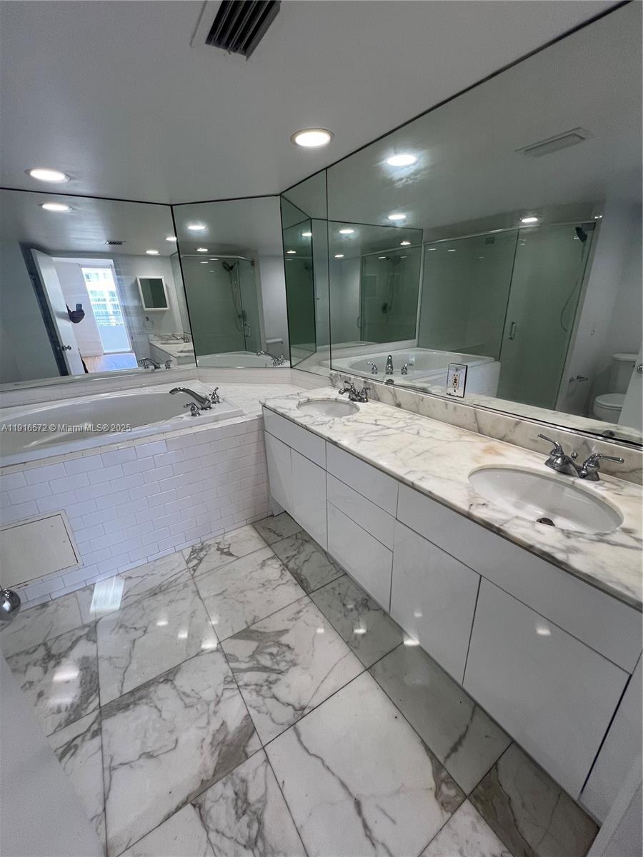 5600 Collins Avenue, Unit 17T Miami Beach, FL 33140 - Photo 32 of 52 a bathroom with a tub sink and mirror