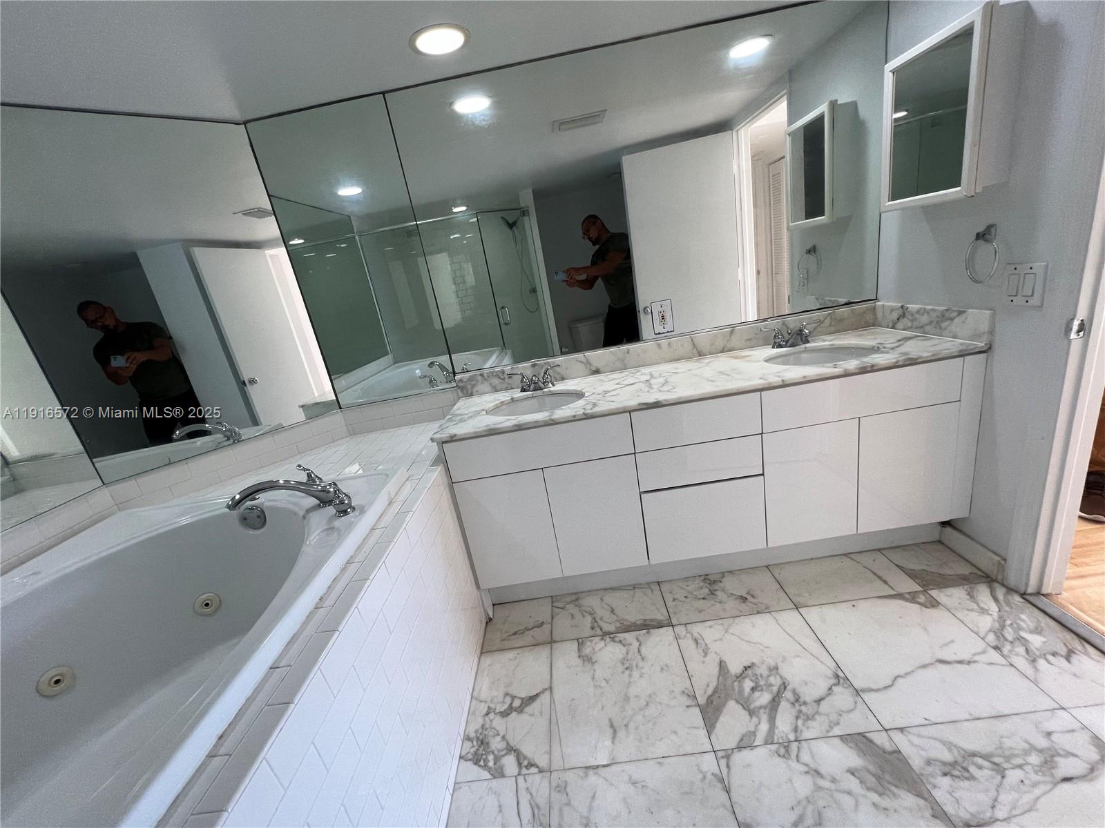 5600 Collins Avenue, Unit 17T Miami Beach, FL 33140 - Photo 34 of 52 a spacious bathroom with a sink mirror and shower