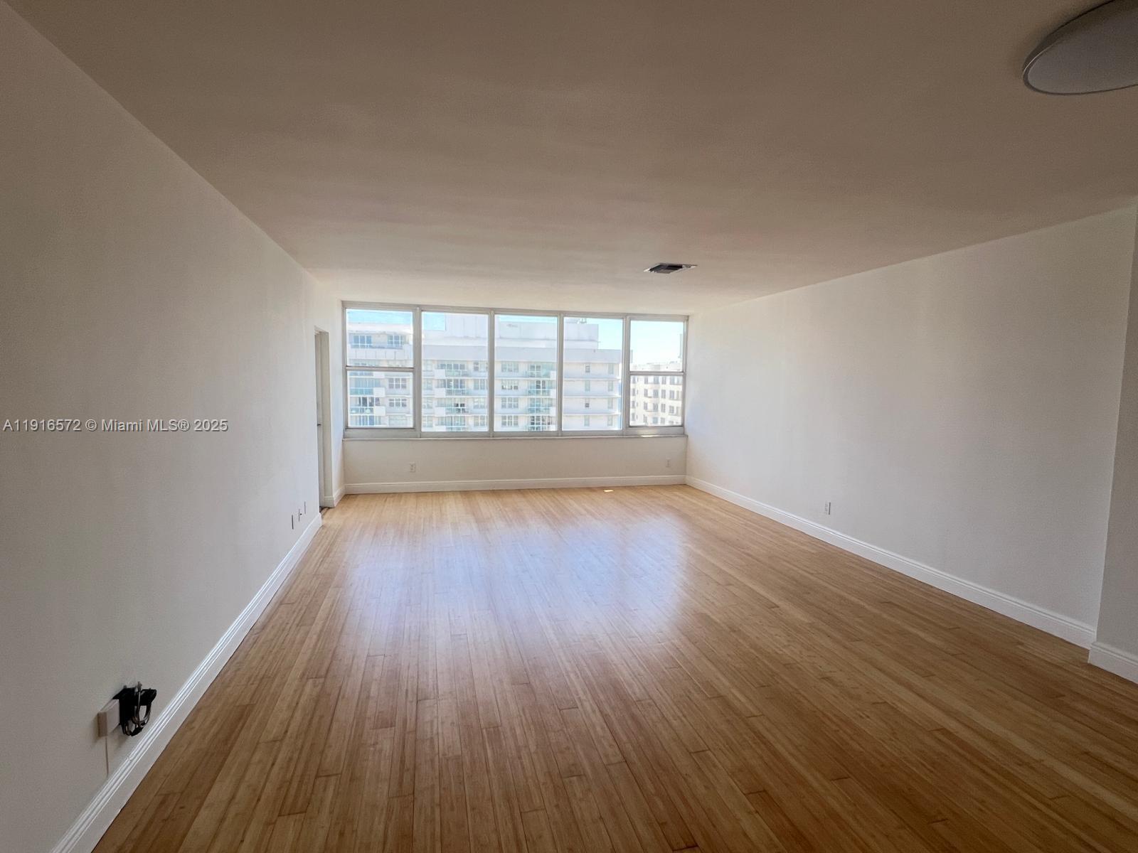 5600 Collins Avenue, Unit 17T Miami Beach, FL 33140 - Photo 4 of 52 wooden floor in an empty room with a window