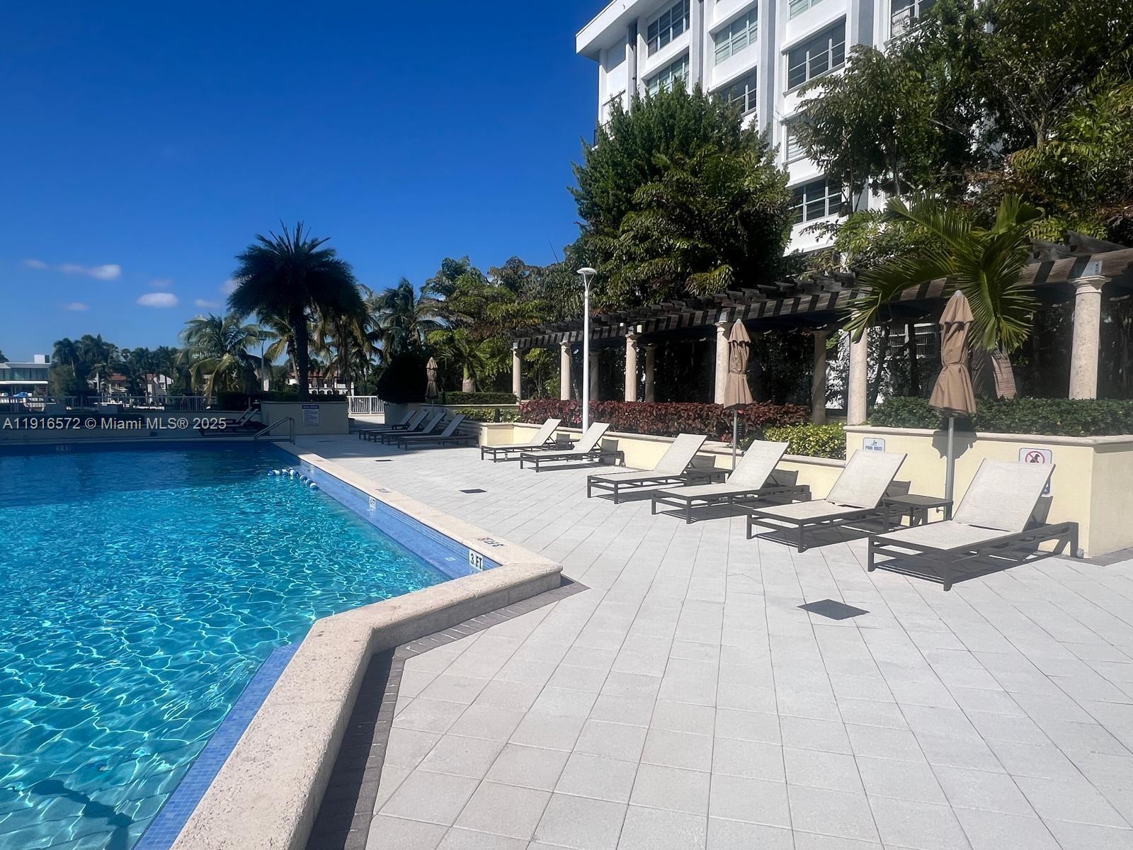 5600 Collins Avenue, Unit 17T Miami Beach, FL 33140 - Photo 50 of 52 a view of swimming pool with outdoor seating and plants