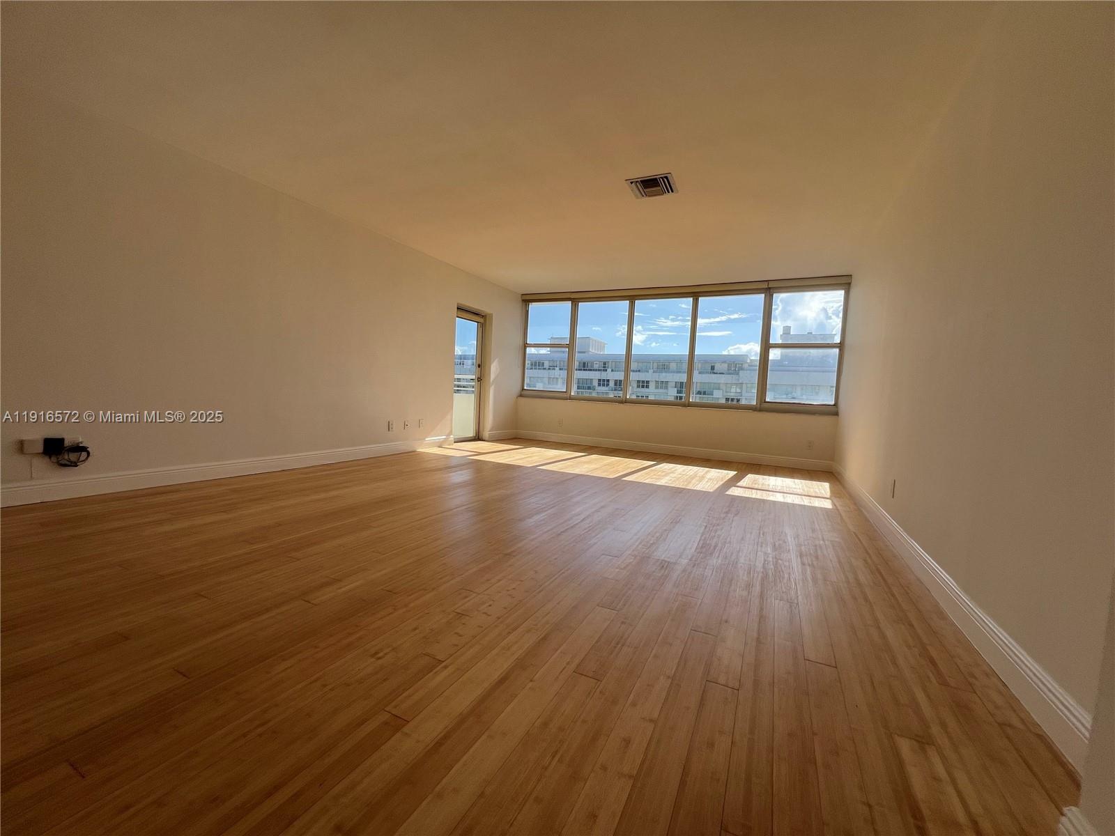5600 Collins Avenue, Unit 17T Miami Beach, FL 33140 - Photo 5 of 52 a view of empty room with wooden floor and fan
