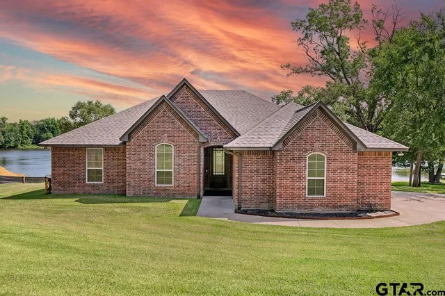a front view of house with yard and trees around