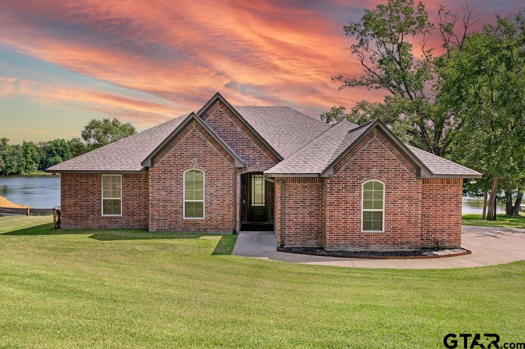 a front view of house with yard and trees around