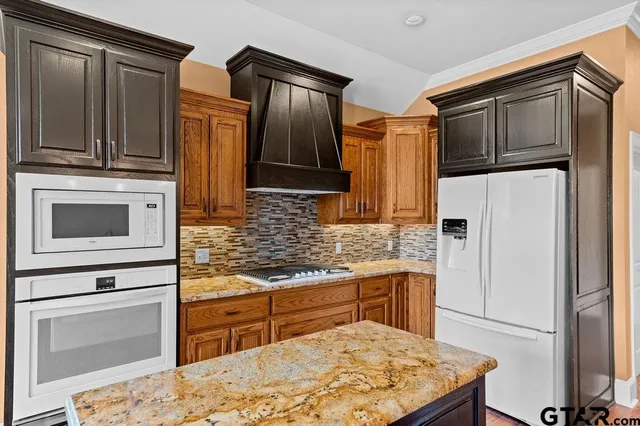 a kitchen with stainless steel appliances granite countertop a refrigerator sink and stove