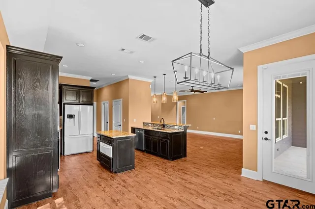 a kitchen view with granite countertop a refrigerator and microwave