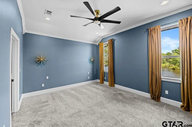 a view of an empty room with a window and a ceiling fan
