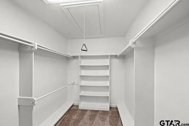 a view of walk in closet with empty racks