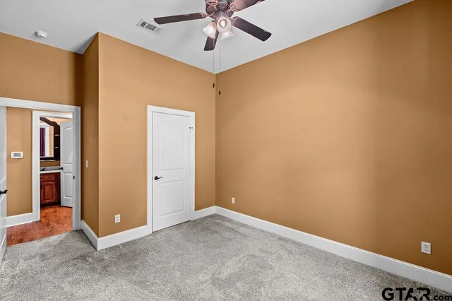 an empty room with closet and fan