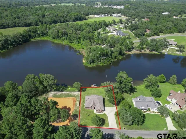 an aerial view of a house with a yard and lake view