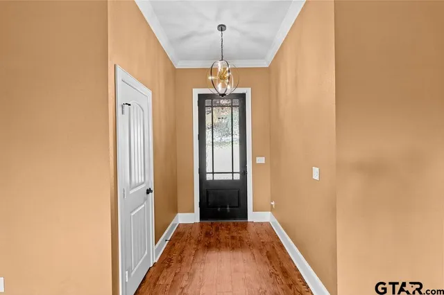 a view of a hallway with wooden floor and staircase