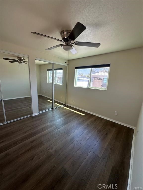 12830 6th Street, Unit 14 Yucaipa, CA 92399 - Photo 16 of 16 an empty room with wooden floor fan and windows