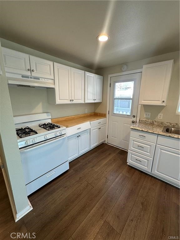 12830 6th Street, Unit 14 Yucaipa, CA 92399 - Photo 9 of 16 a kitchen with granite countertop a stove and cabinets