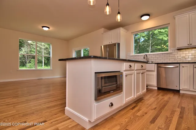 a kitchen with stainless steel appliances a stove a sink and a microwave