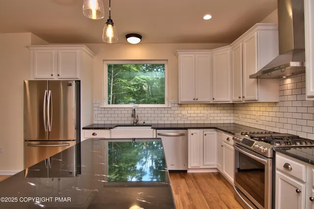 a kitchen with stainless steel appliances granite countertop a sink stove and refrigerator