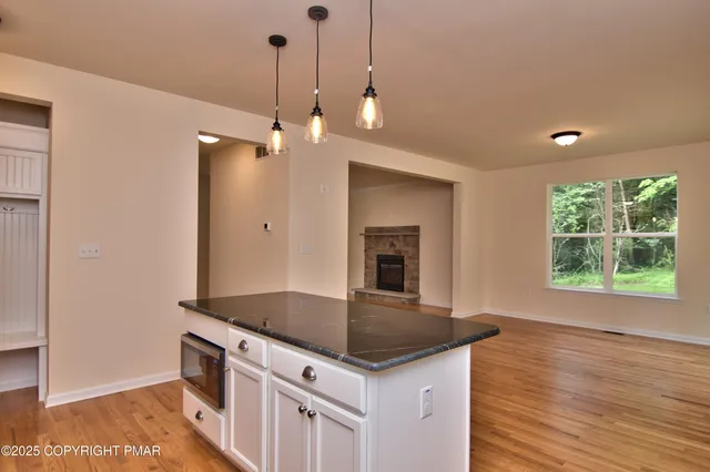 a kitchen with stainless steel appliances granite countertop a sink a stove and a wooden floors