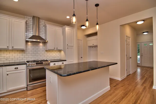a kitchen with stainless steel appliances granite countertop a sink a stove and a refrigerator
