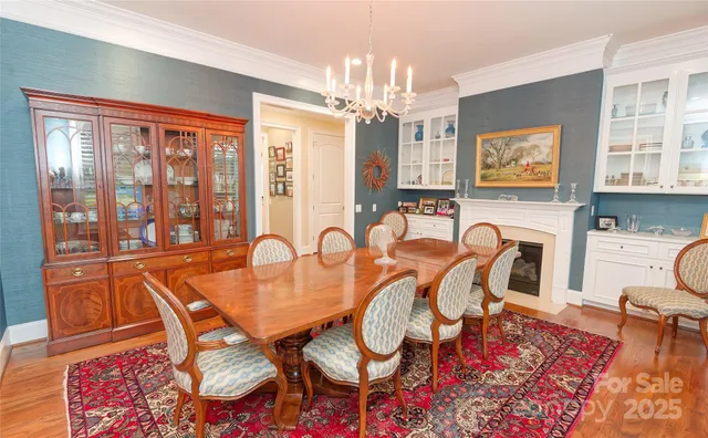 a dining room with furniture a chandelier and wooden floor