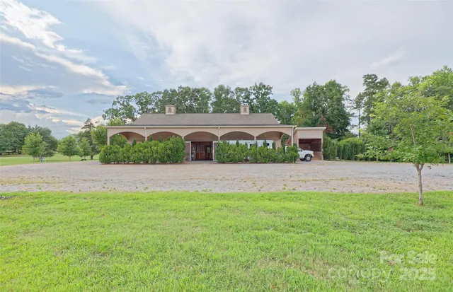 a front view of a house with a yard and trees